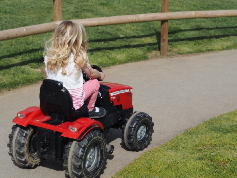 Girl riding pedal tractor