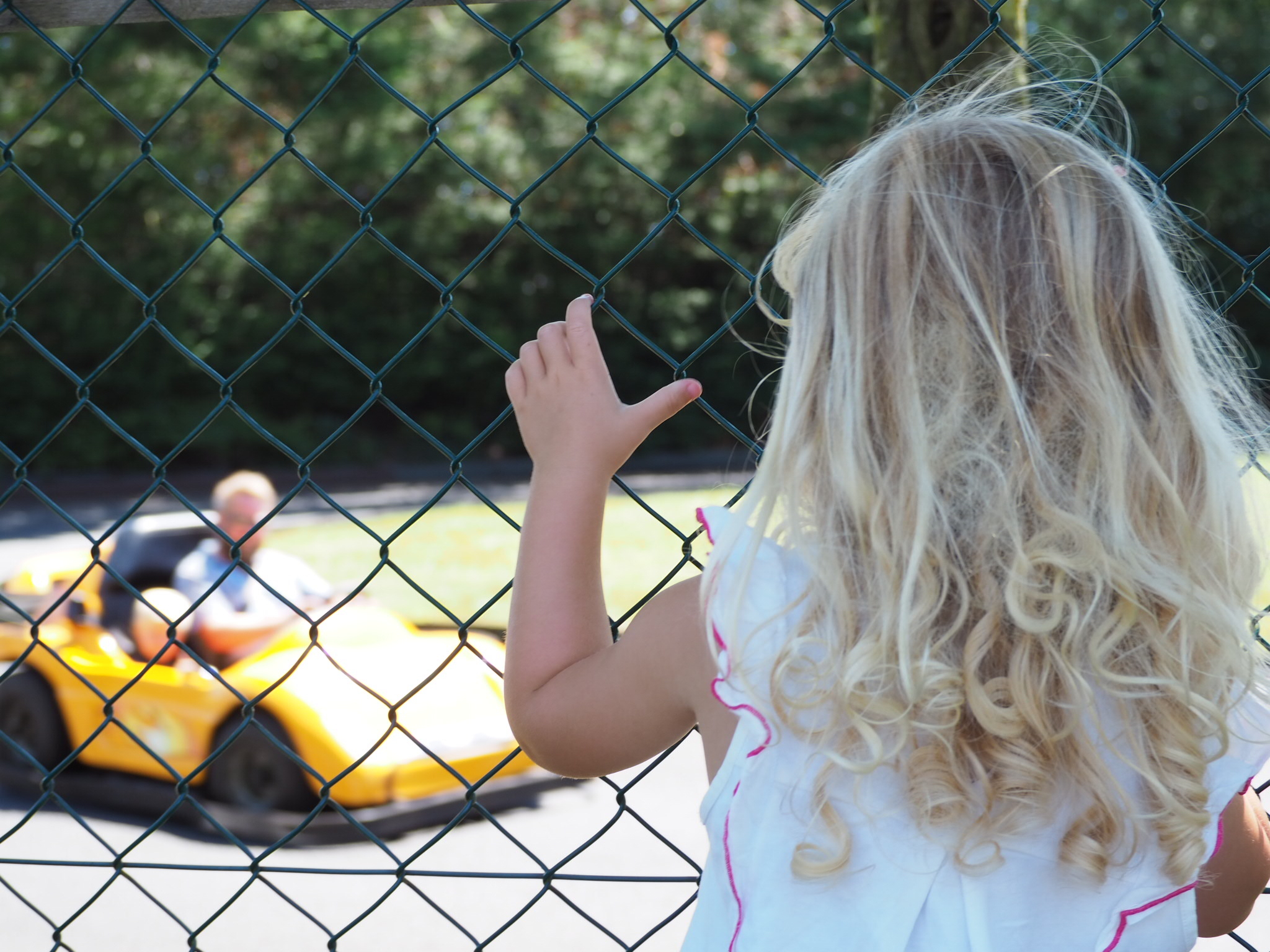 Little girl watching daddy and brother on the go karts at Folly Farm