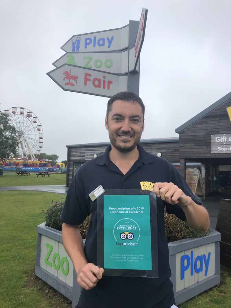 Team member displaying TripAdvisor award