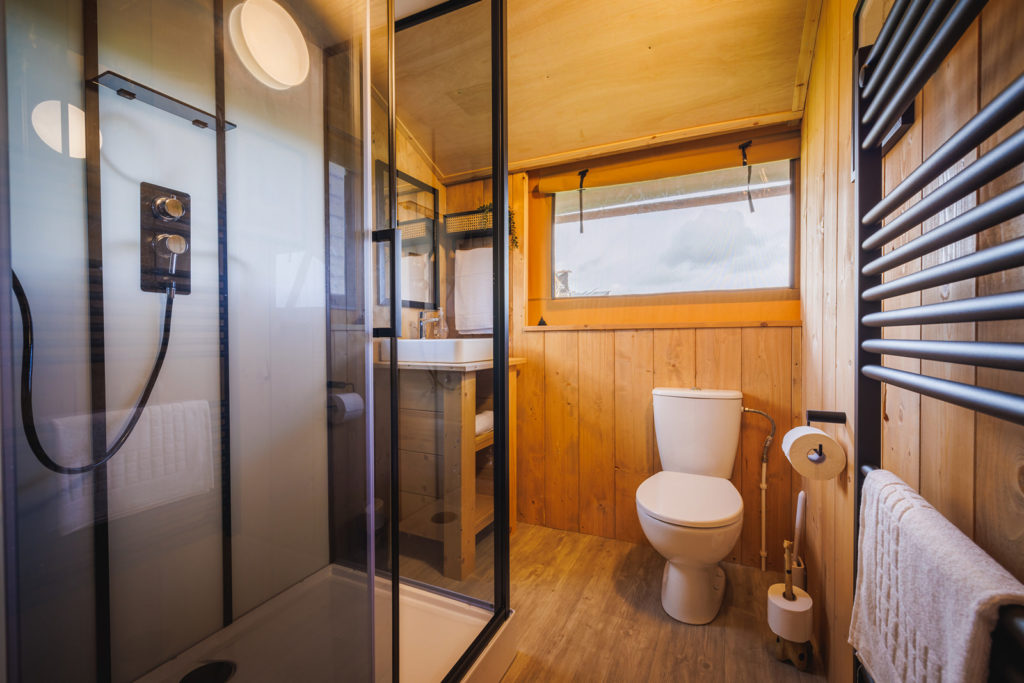 Photo of shower cubicle, toilet, sink and heated towel rail.